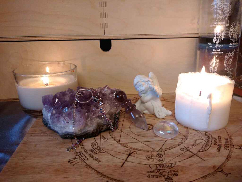Pendulum board with candles and angel figurine